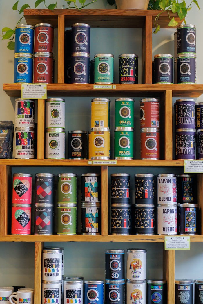 A vibrant display of assorted coffee cans on wooden shelves indoors.